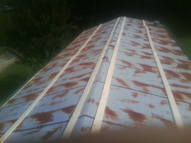 Rusted metal roof panels with new wood purlins before replacement — Storm Damage Roof Repair in Beloit by Roofing Brothers